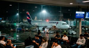 Avião da LATAM no pátio do aeroporto iluminado durante a madrugada para post sobre voos noturnos.